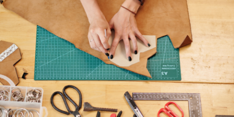 Hands making leather jewelry