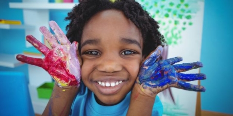 Little boy with messy hands from fingerpainting
