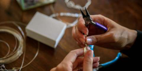 hands crafting stones into jewelry