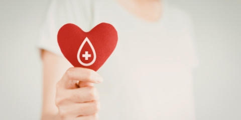 image of a hand holding a heart with a blood drop graphic