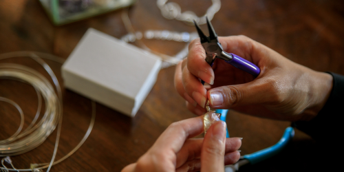 hands crafting stones into jewelry