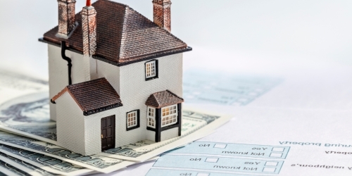 model of a house on estate paperwork